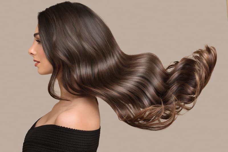 Młoda kobieta z długimi, falowanymi włosami glass hair od boku